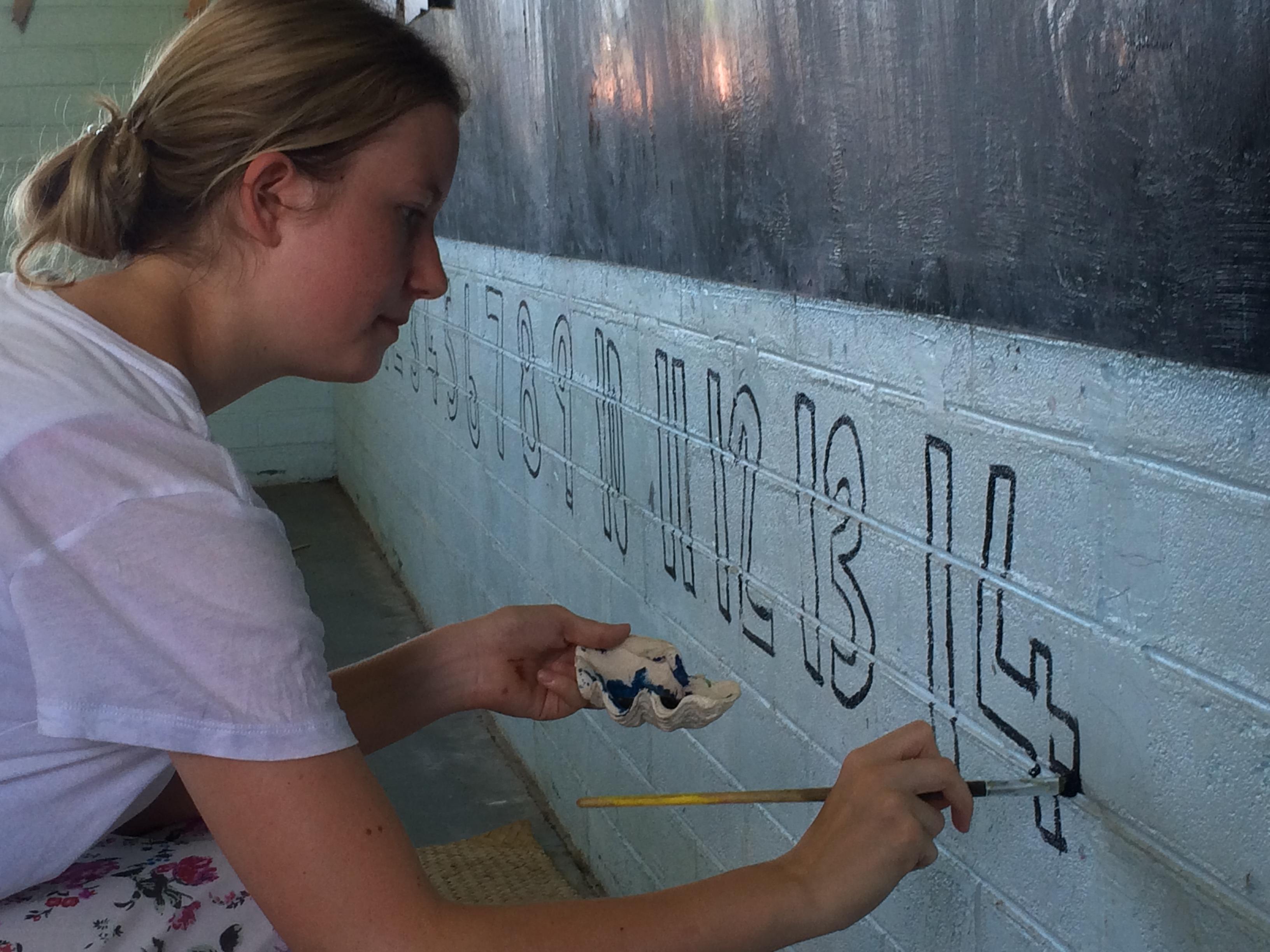 A Projects Abroad Care volunteer paints a classroom in Samoa A Care volunteer in Samoa revitalises a classroom by painting numbers